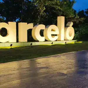 Entrance sign of Barceló Maya Riviera at dusk with a white van passing by.