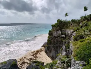 Paysage emblématique des ruines de Tulum situées sur une falaise face aux eaux turquoise du Mexique.